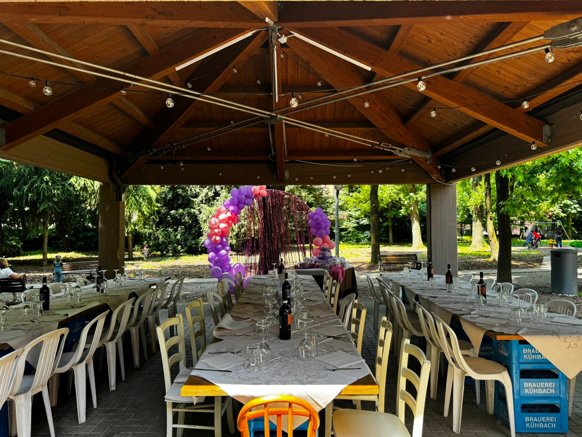Allestimento cerimonia sotto il gazebo con tavoli imbanditi e arco di palloncini